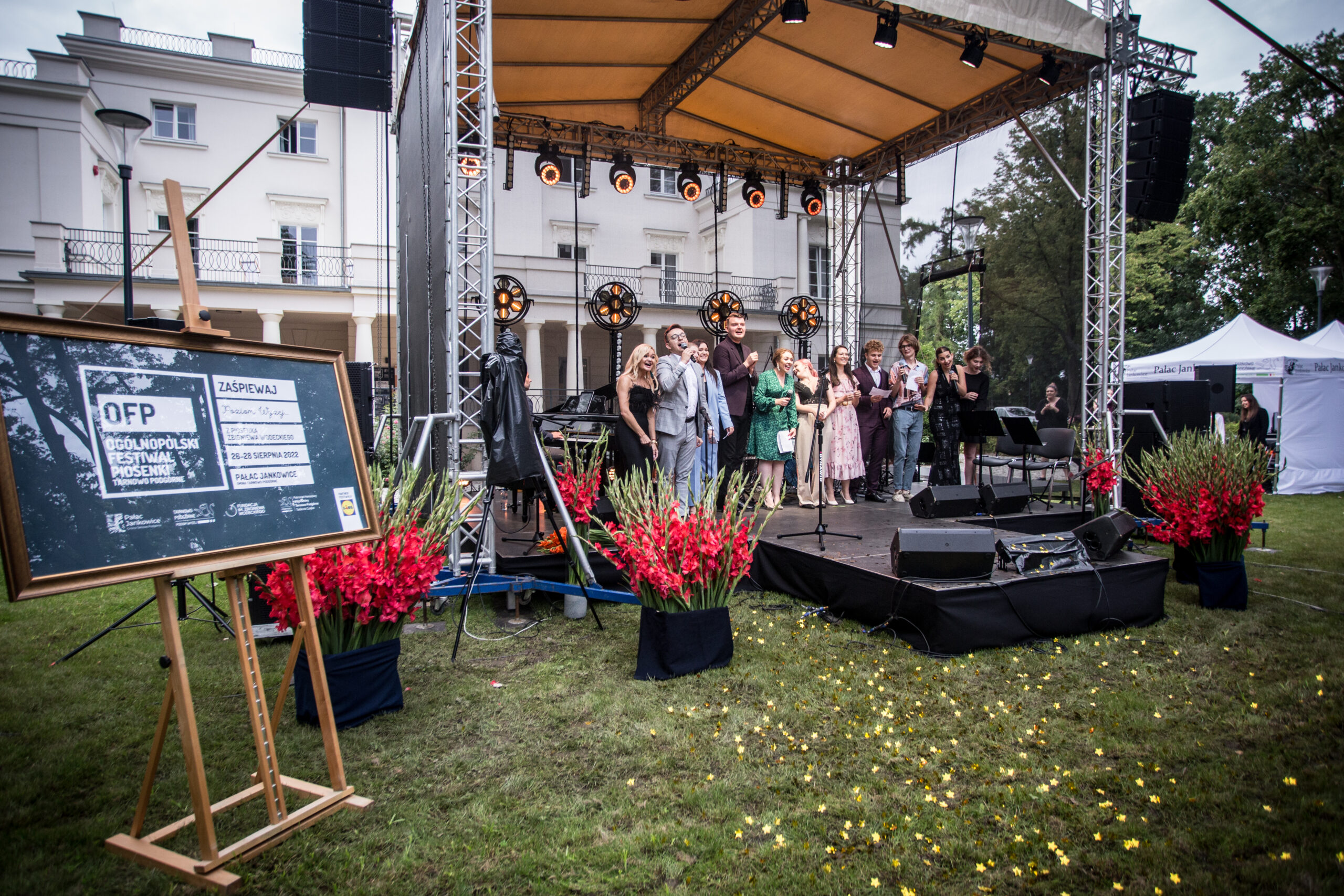 Scena przy Pałacu Jankowice, a na niej uczestniczy festiwalu śpiewający festiwalową piosenkę