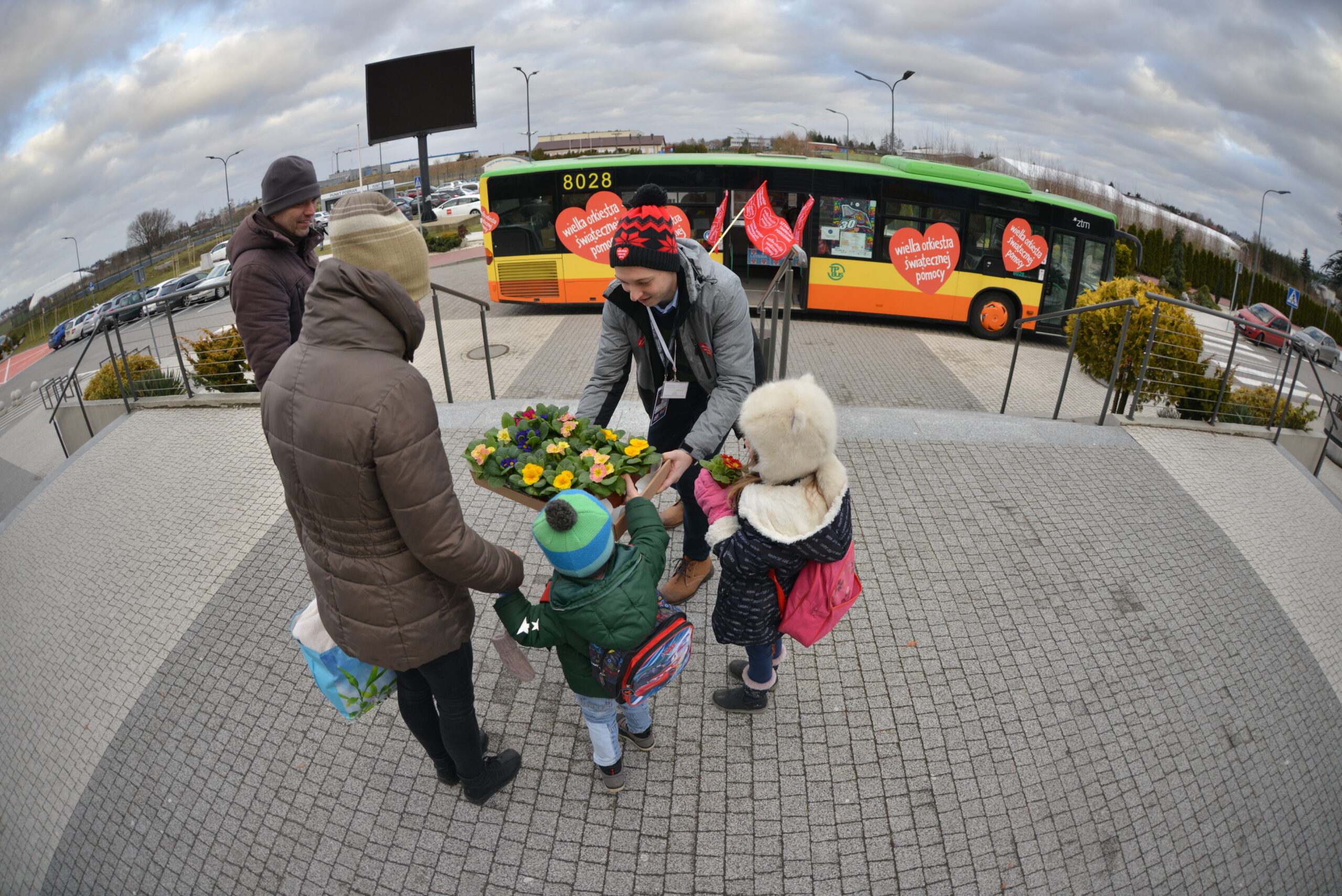 Wolontariusz wręczający kwiatki podczas 30. Finału WOŚP w Gminie Tarnowo Podgórne